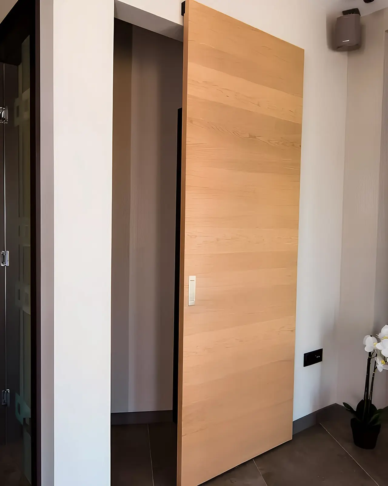 Geöffnete wandlaufende Schiebetür aus hellem Holz